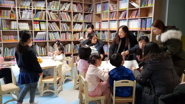 새단장으로 쾌적해진 유아 독서 공간에서 아이들과 학부모들이 즐거워하고 있다(개관식풍경)
